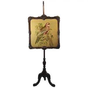 May include: A wooden fire screen with a bird embroidered on the fabric panel. The screen has a carved frame and a tripod base.