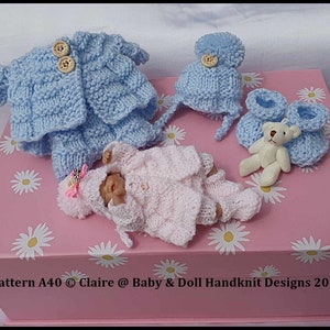 May include: A collection of hand-knitted baby clothes in soft blue and pink hues. The set includes a jacket, hat, booties, and a doll-sized outfit, along with a small teddy bear. The text "Pattern A40 Claire @ Baby & Doll Handknit Designs 2024" is visible.