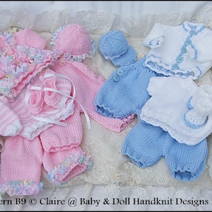 Può includere: Due set di vestiti per neonati a maglia, uno rosa e uno blu. Il set rosa comprende un cappello, un maglione e pantaloni con volant. Il set blu comprende un cappello, un maglione e pantaloni. I set sono disposti su uno sfondo di pizzo bianco. Modello B9 © Claire @ Baby & Doll Handknit Designs 2007