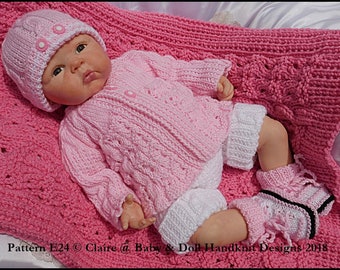 May include: A pink knitted baby outfit with a white knitted hat, a pink cardigan, white shorts, and pink and white booties. The outfit is laid out on a pink knitted blanket.