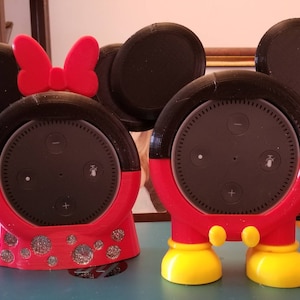 May include: Two 3D printed Amazon Echo Dot speaker covers. One is Mickey Mouse and the other is Minnie Mouse. Both are red and black with yellow feet.