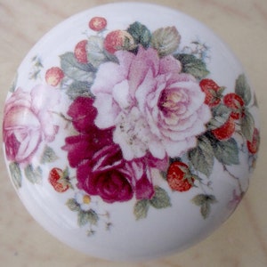 May include: White ceramic knob with a floral design featuring pink and purple roses, green leaves, and red berries.