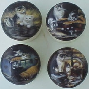 May include: Four round ceramic tiles with images of cats. Each tile features a different scene with multiple cats in various poses. The tiles are white with a glossy finish.