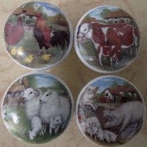 May include: Set of four ceramic knobs featuring farm animals. Each knob depicts a different animal, including a rooster, cow, sheep, and pig. The knobs are painted in a colorful, whimsical style.
