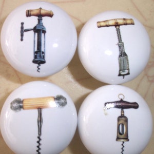 May include: Four white ceramic cabinet knobs with different vintage corkscrew designs. Each knob features a different style of corkscrew with a wooden handle.