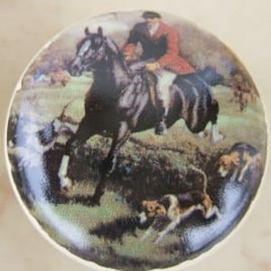 May include: A ceramic knob with a vintage illustration of a rider on horseback with hounds chasing a fox in a field.