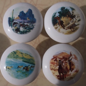 May include: Set of four white ceramic knobs with colorful images of horses and landscapes. The knobs are round and have a smooth, glossy finish.