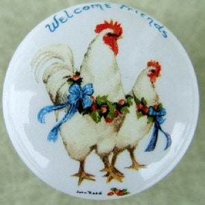 May include: A white ceramic plate with a blue and white illustration of two chickens wearing holly wreaths and blue ribbons. The text "Welcome Friends" is written in blue around the edge of the plate.