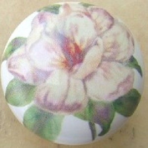 May include: A white ceramic knob with a pink flower and green leaves painted on it.