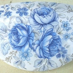 May include: A white ceramic oval dish with a blue and white floral design. The design features blue roses and smaller blue flowers on a white background.