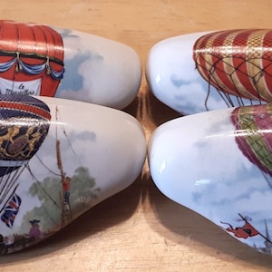May include: Four ceramic drawer pulls shaped like hot air balloons. Each pull features a different colored balloon with a white background and a sky scene.