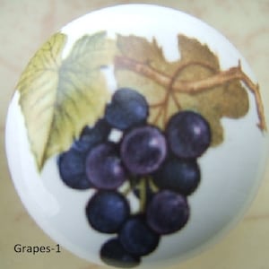May include: White ceramic cabinet knob featuring a cluster of dark purple grapes and green and brown grape leaves. The knob has a round shape and is suitable for furniture or decorative use. The text "Grapes-1" is at the bottom.