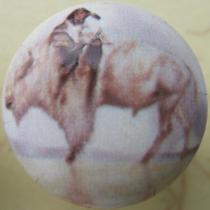 May include: A round button featuring a sepia-toned illustration of a person riding a bison. The rider is wearing a hat and appears to be holding reins. The bison is depicted in a walking pose. The button has a fabric-like texture.