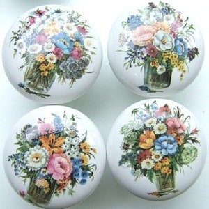 May include: Four white ceramic knobs with floral designs. Each knob features a bouquet of colorful flowers in a glass jar.