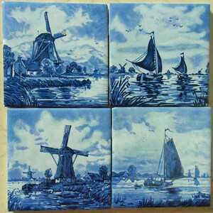 May include: Four blue and white Delft tiles depicting Dutch scenes. The tiles feature windmills, boats, and water. The tiles are painted in a traditional blue and white style.