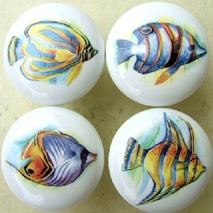 May include: Set of four ceramic cabinet knobs featuring colorful tropical fish designs. Each knob has a white background with a different fish species, including a yellow and blue fish, a blue and black fish, a purple and orange fish, and a yellow and orange fish.