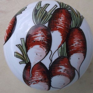 May include: A white ceramic knob featuring a hand-painted design of red radishes with green tops. The radishes are clustered together, creating a vibrant and fresh aesthetic. This decorative knob is suitable for kitchen or garden-themed decor.