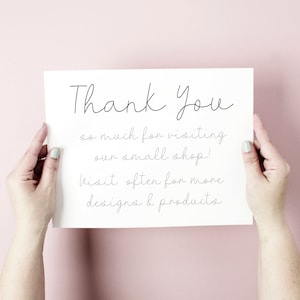May include: A white card with black handwritten text that says "Thank You so much for visiting our small shop! Visit often for more designs & products".