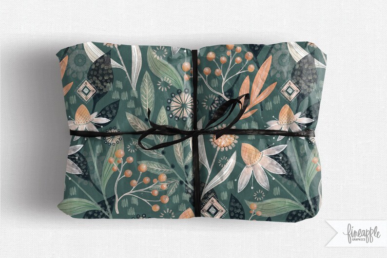 May include: Gift-wrapped package with a dark teal floral pattern featuring white, orange, and green botanical elements. The package is tied with a black ribbon. The design includes stylized flowers, leaves, and berries.