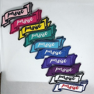 May include: Ten embroidered iron-on patches with the word "persist" in a variety of colors, including pink, red, yellow, green, blue, purple, and white. The patches are in the shape of a banner.