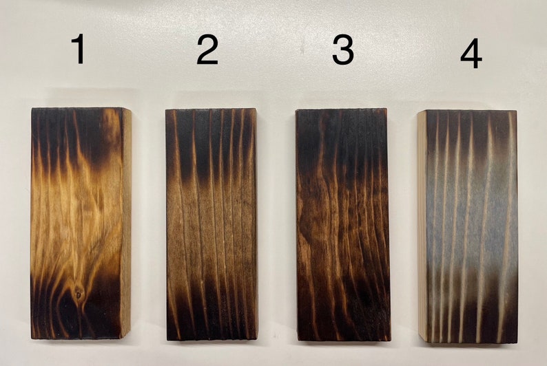 May include: Four wood samples with different levels of charring, labeled 1 through 4. The samples are arranged from lightest to darkest charring.