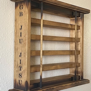 May include: A wooden wall-mounted shelf with a burnt finish. The shelf has five shelves and is labeled "GBJJU" on the side.