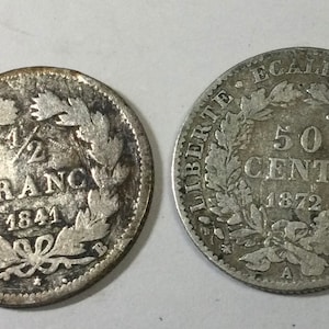 May include: Two silver French coins, one is a half franc from 1841 and the other is a 50 cent piece from 1872.