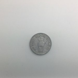 May include: A silver Thai coin with the inscription "THAI BANK NOTE COMPANY" and the year "1961" on the front.