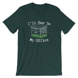 May include: A dark green t-shirt with a white graphic of a beehive with bees flying around it. The text "I'll Bee In My Office" is printed below the beehive.