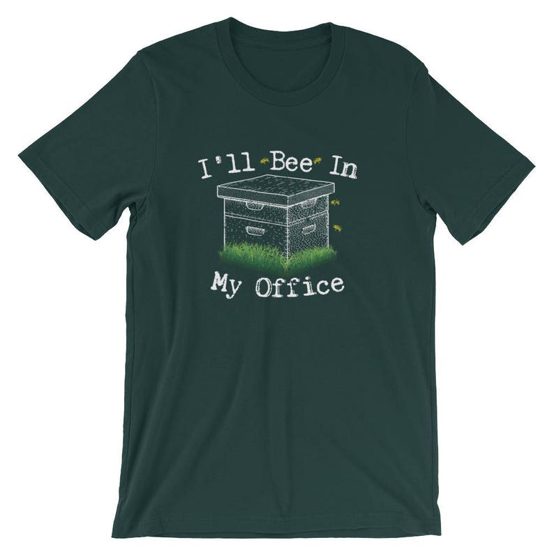 May include: A dark green t-shirt with a white graphic of a beehive with bees flying around it. The text "I'll Bee In My Office" is printed below the beehive.