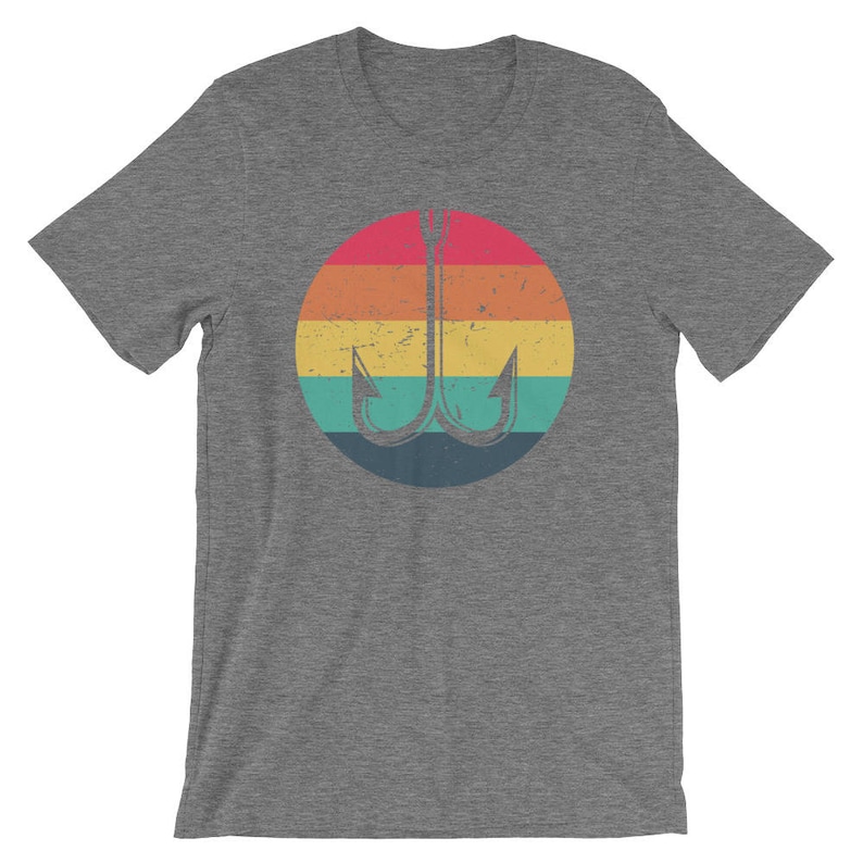 K&ouml;nnte beinhalten: Ein heidefarbenes T-Shirt mit einer Retro-Grafik eines Angelhakens in einem regenbogenfarbenen Kreis.