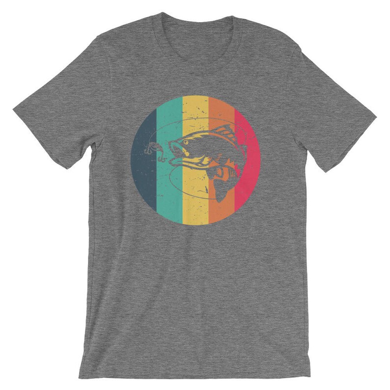May include: A heather grey t-shirt with a retro-style graphic of a fish being caught on a fishing line. The graphic is in a circle with a rainbow background.