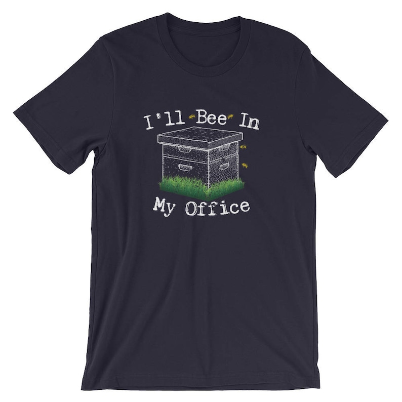 May include: A navy blue t-shirt with a white graphic of a beehive and the text "I'll Bee In My Office".