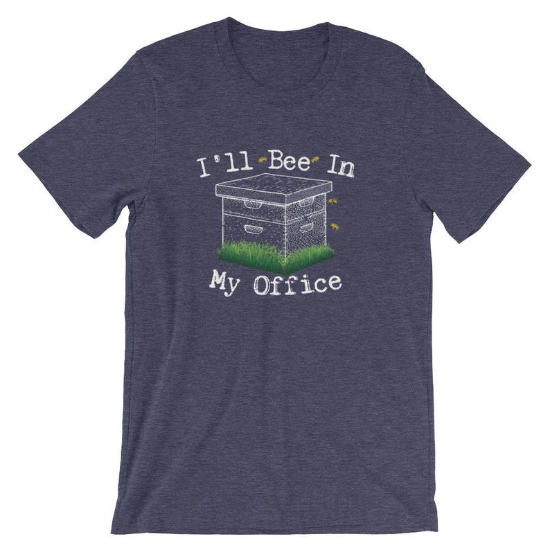 May include: A navy blue t-shirt with a white graphic of a beehive and the text "I'll Bee In My Office".