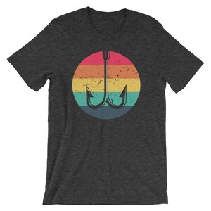 K&ouml;nnte beinhalten: Ein dunkelgraues T-Shirt mit einem regenbogenfarbenen Kreis, der einen schwarzen Angelhaken zeigt. Der Kreis hat einen abgenutzten Vintage-Look.