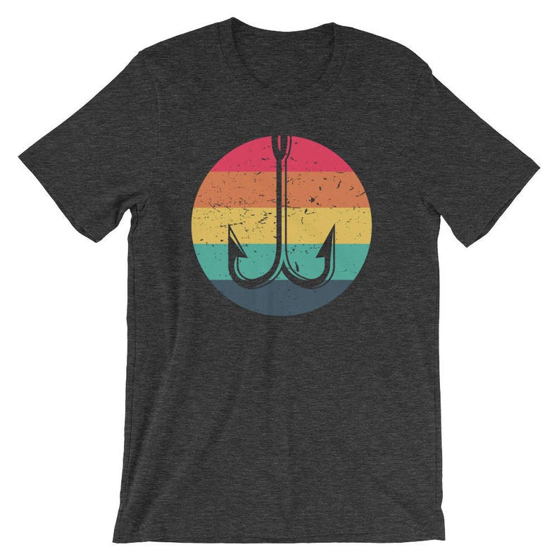 K&ouml;nnte beinhalten: Ein dunkelgraues T-Shirt mit einem regenbogenfarbenen Kreis, der einen schwarzen Angelhaken zeigt. Der Kreis hat einen abgenutzten Vintage-Look.