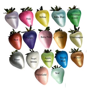 May include: A collection of 16 strawberry-shaped ornaments in various colors, including lavender, pink, yellow, baby blue, Christmas green, purple, baby pink, gold, champagne, red, pearl white, silver, apple green, royal blue, bronze, teal, and rose gold.