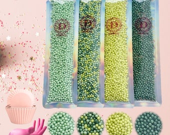 May include: Four bags of green, yellow, and blue pearl sprinkles. The bags are labeled "D.D. Sprinkles".