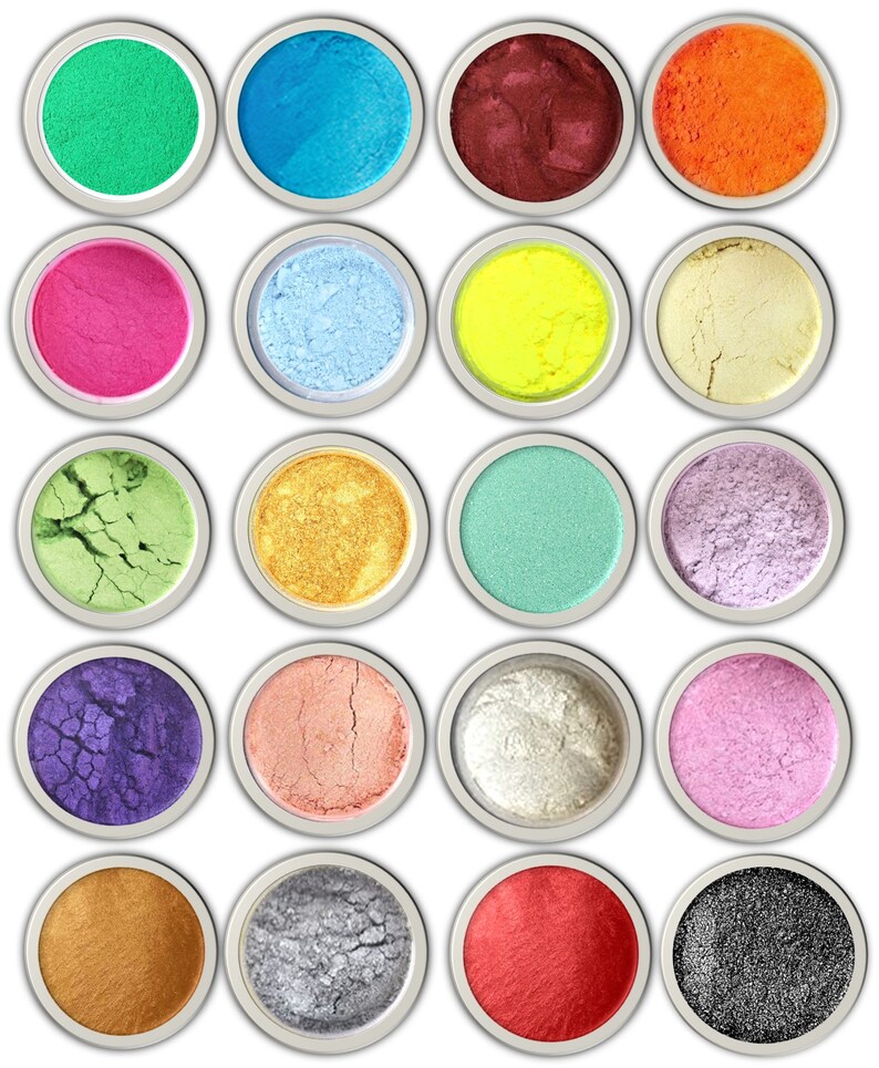K&ouml;nnte beinhalten: Zwanzig runde Beh&auml;lter mit bunten Pigmenten, jeder mit einem anderen Farbton, darunter Gr&uuml;n, Blau, Rot, Orange, Pink, Gelb, Gold, Silber und Schwarz.