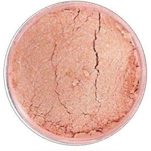 May include: A small jar of shimmery, peach-colored mica powder. The powder is fine and has a pearlescent finish.
