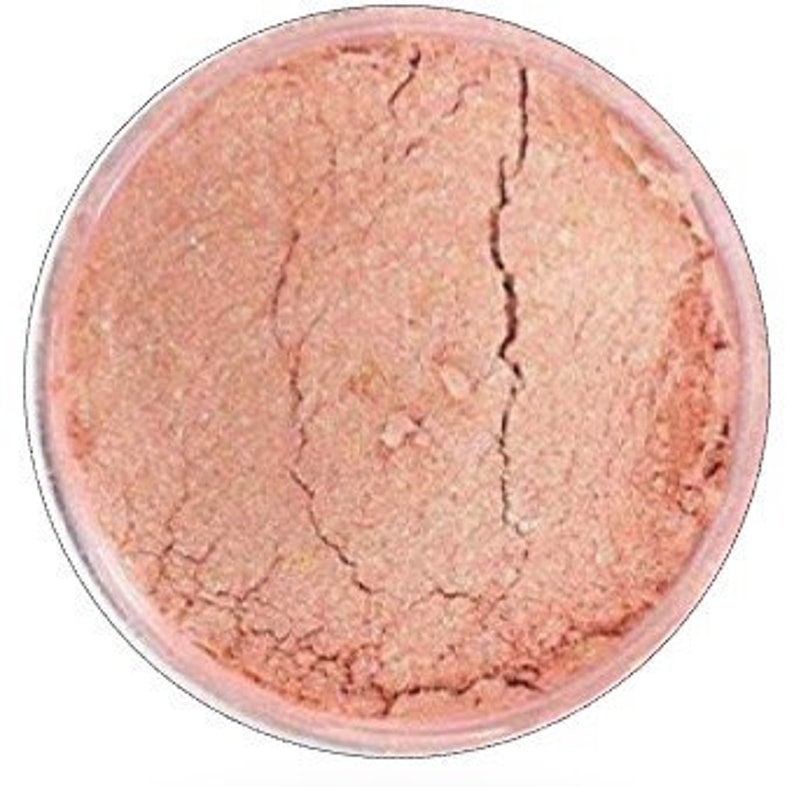 May include: A small jar of shimmery, peach-colored mica powder. The powder is fine and has a pearlescent finish.
