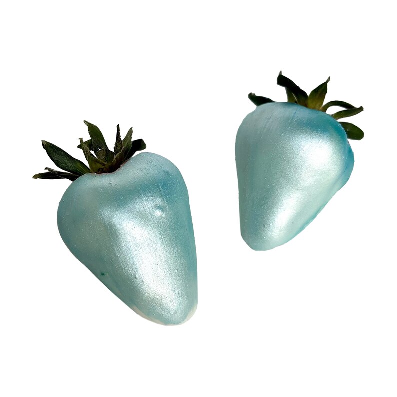 May include: Two blue, metallic-looking strawberries with green leaves.