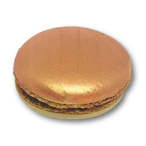 May include: A single, round, rose gold macaron with a light brown filling. The macaron is on a white background.