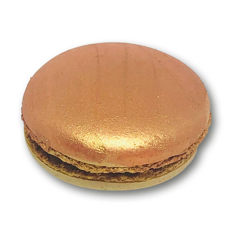May include: A single, round, rose gold macaron with a light brown filling. The macaron is on a white background.