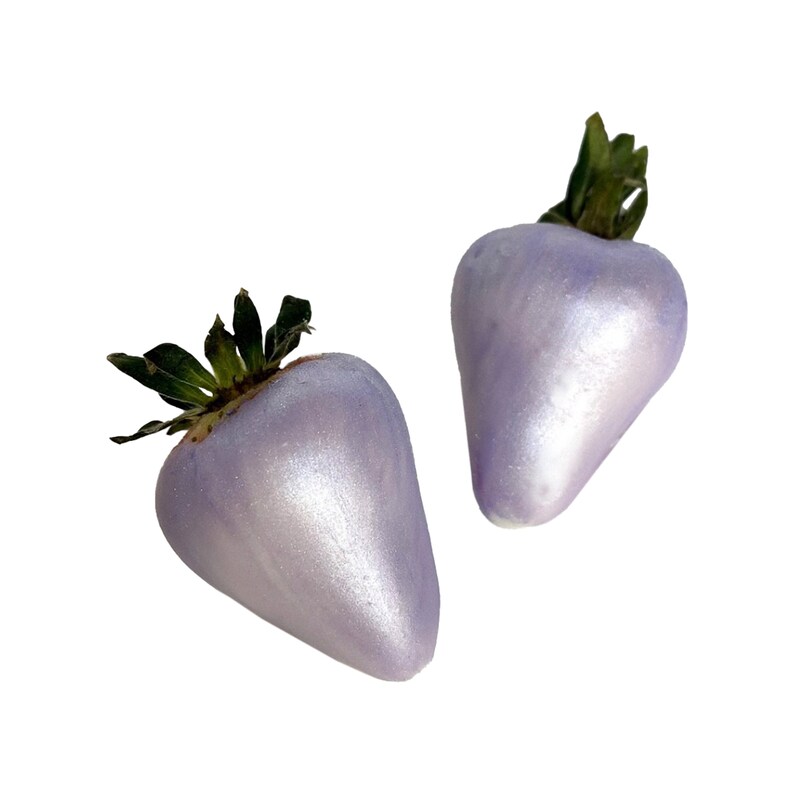 May include: Two purple, shiny, faux strawberries with green leaves.