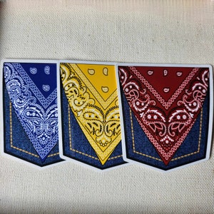 May include: Three bandana print stickers with a denim pocket design. The bandanas are blue, yellow, and red.