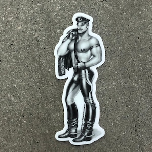 May include: Black and white sticker of a man wearing a leather outfit, a cap, and boots. The sticker has the text "Bert Stern of The Naked Foundation" on the bottom right corner.