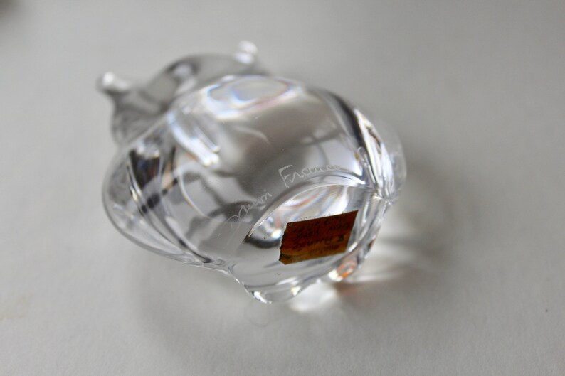 May include: Clear glass owl figurine with a textured surface. The owl has a label on the bottom that reads "Cristal France".