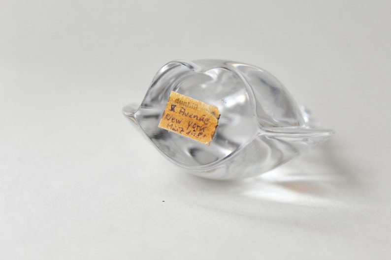 May include: A clear glass sculpture with a label that reads "Dunhill 5 Avenue New York Mail 7-11-59."