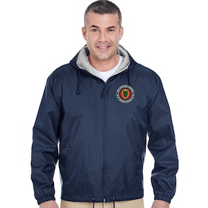 May include: A navy blue hooded jacket with a zipper closure. The jacket has a patch on the left chest with the text "1st Infantry Division" and "Big Red One".